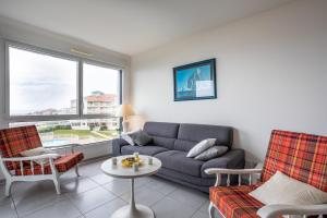 a living room with a couch and a table at Les voiles du large in Les Sables-dʼOlonne
