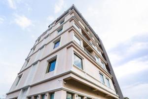 a tall white building with windows on top of it at hotel-montreal rishikesh madhuban inn in Rishīkesh