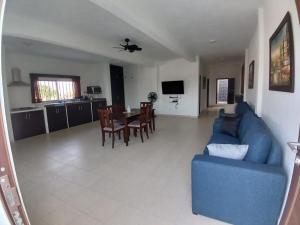 ein Wohnzimmer mit einem blauen Sofa und einem Tisch in der Unterkunft Casa Garcia - Alberca privada in Tequesquitengo