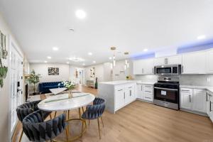a kitchen with white cabinets and a table and chairs at Xlnc Exotic home13824 Powers Rd in Poway