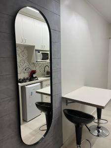 Un espejo en una cocina con una mesa y dos taburetes. en Brasília Kit Sudoeste, en Brasilia
