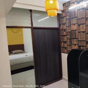チェンナイにあるHygge suitesのベッド1台と鏡が備わる部屋