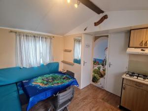 a small room with a bed and a kitchen at Mobilhome Océalia T3 in Plouescat
