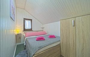 a bedroom with a bed with pink pillows on it at House Kiki by Villas Guide in Bosiljevo +45 photos