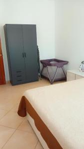 a bedroom with a bed and a cabinet and a table at Kyara beleza apartamento in Prainha