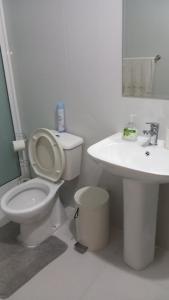 a white bathroom with a toilet and a sink at Kyara beleza apartamento in Prainha