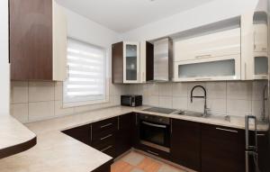 a kitchen with brown cabinets and a sink at Villa Tea - Makarska by Villas Guide in Gornji Vinjani