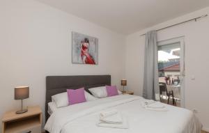 a bedroom with a large white bed with pink pillows at Villa Bilanzic - Omis by Villas Guide in Kreševo +22 photos