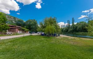 Ein Park neben einem Fluss mit Leuten, die auf dem Gras sitzen. in der Unterkunft Villa Bilanzic - Omis by Villas Guide in Kreševo