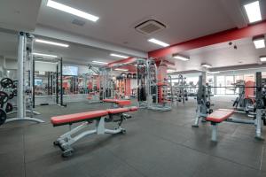 a gym with lots of machines and red benches at Mercure Warragul in Warragul