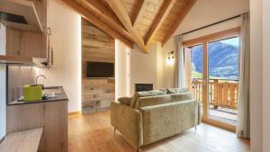 a living room with a couch and a balcony at Zarabella Delle Alpi in Temù