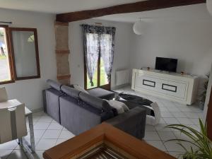 a living room with a couch and a tv at Gîte pres de Giverny in Gasny