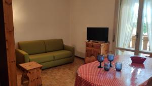 a living room with a couch and a table with wine glasses at Casa Nelly by Ca-Sa Check in Andalo