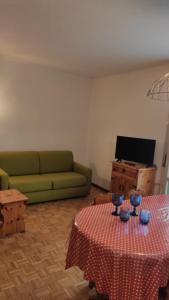 Una sala de estar con un sofá verde y una mesa. en Casa Nelly by Ca-Sa Check, en Andalo
