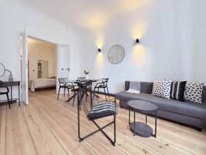 a living room with a couch and a table and chairs at Studios am Kniepertor Altstadt Stralsund in Stralsund
