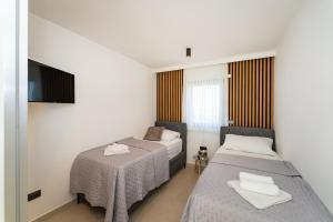 a hotel room with two beds and a television at MY DALMATIA - Beach Apartment LaMag in Vrsi +64 photos