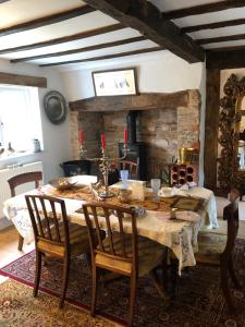 a dining room with a table and a fireplace at Logaston Common Farmhouse in Woonton