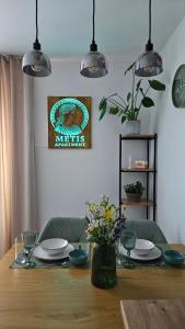 a dining room table with plates and flowers on it at METIS Apartment in Martin