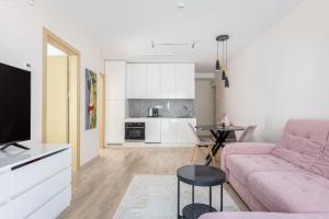 un soggiorno con un divano rosa e un tavolo di Mill Central a Palanga