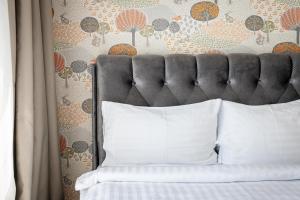 un letto con cuscini bianchi di fronte a un muro di Mill Central a Palanga