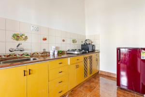 a kitchen with yellow cabinets and a red refrigerator at Calissa Cottage 2BHK Mall Road in Mussoorie +42 photos