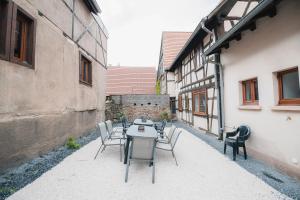 a table and chairs in a courtyard of a building at APPARTEMENT ELSA - Au Calme des Vignes - Parking privatif & Animaux Bienvenus in Dambach-la-Ville