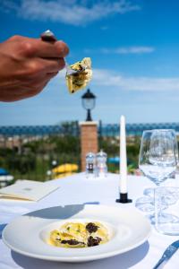 a person eating food on a table with a plate of food at Vigneto - Italian Restaurant & B&B in Villa Rosa