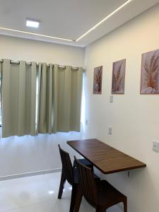 a dining room with a wooden table and two chairs at Studio Centro Coité in Conceição do Coité