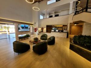 a lobby with chairs and a table in a building at Fênix Plaza Hotel in Aquidauana