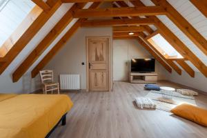a bedroom with a bed and a tv in a attic at Gîte Gîte de Reyrac 7/8 personnes in Brion