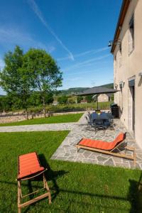 a patio with two chairs and a table and a grill at Gîte Gîte de Reyrac 7/8 personnes in Brion