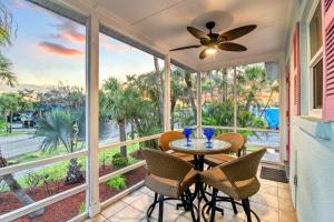 a porch with a table and chairs and a ceiling fan at Tidal Wave - In Siesta Key Village, Pet Friendly, Private Pool! in Siesta Key