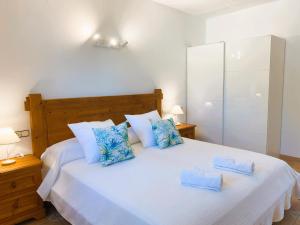 サン・ジョセップ・デ・サ・タライアにあるVilla Taridaの大きな白いベッドと青い枕のある寝室