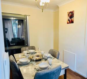 a dining room table with chairs and a table with plates at Ace Space 2 in Stifford