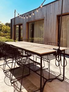a wooden table and chairs on a patio at DUNE, Maison Littoral by BLOSS stylish apartment with garden and terrace in De Haan +19 photos