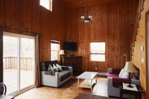 ein Wohnzimmer mit Sofa und Tisch in der Unterkunft Lanes Riverhouse Inn & Cottages in Montague