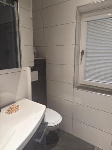 ein Badezimmer mit Toilette und Waschbecken und einem Fenster in der Unterkunft Komfortzimmer im modernen Stil in Trieben