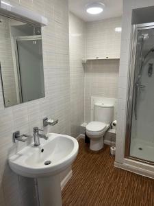 un bagno bianco con lavandino e WC di The Ardingly Inn a Ardingly