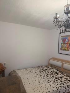 Schlafzimmer mit einem Bett mit Kronleuchter in der Unterkunft Komfortzimmer im modernen Stil in Trieben