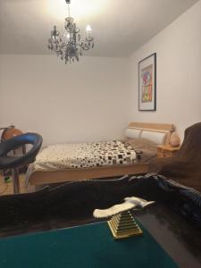 ein Wohnzimmer mit 2 Betten und einem Kronleuchter in der Unterkunft Komfortzimmer im modernen Stil in Trieben