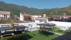 a patio with tables and chairs on a roof at Villa Beso Casa Rural in Otívar