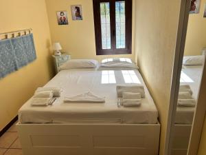 une chambre avec un lit avec des serviettes dessus dans l'établissement Villa SuReu, à Castiadas