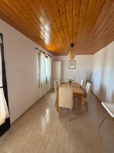 a dining room with a wooden ceiling and a table and chairs at Villa Sarah in Playa Blanca