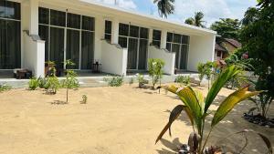 a house with a lot of plants in front of it at Kujaku in Arugam Bay