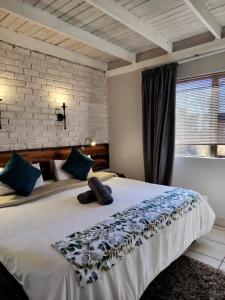 a bedroom with a large white bed with blue pillows at Weltevreden Game Lodge in Bloemfontein +50 photos