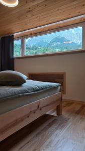 a bedroom with a bed with a large window at Hiša za Gradom in Kobarid