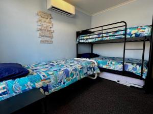 1 Schlafzimmer mit 2 Etagenbetten und einem Ventilator in der Unterkunft Tropical Palms - Kalbarri, WA in Kalbarri + 10 Fotos