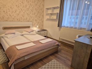 a bedroom with a bed with two towels on it at Apartament de închiriat in Borsec