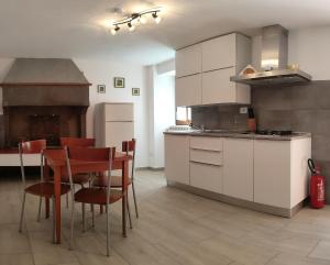 a kitchen with white cabinets and a table and chairs at Casa Milu in Stazione di Santa Mama