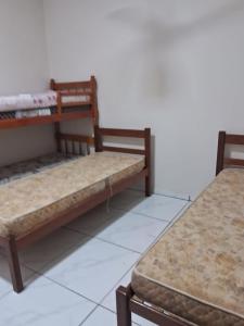 two beds sitting next to each other in a room at Casa compartilhada em Itaúnas - Centro da Vila in Conceição da Barra